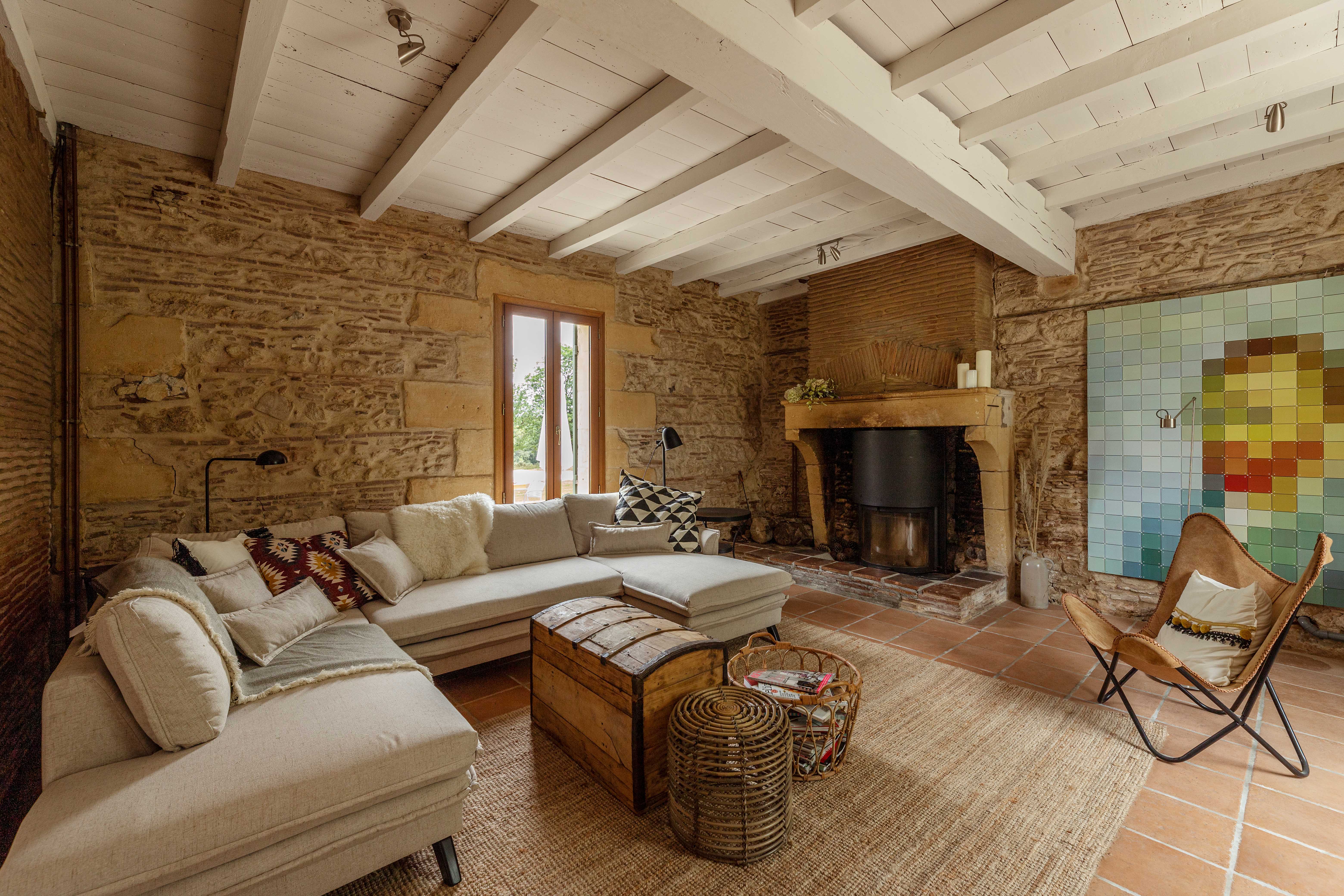 Spacious living area with woodburner in restored French farmhouse